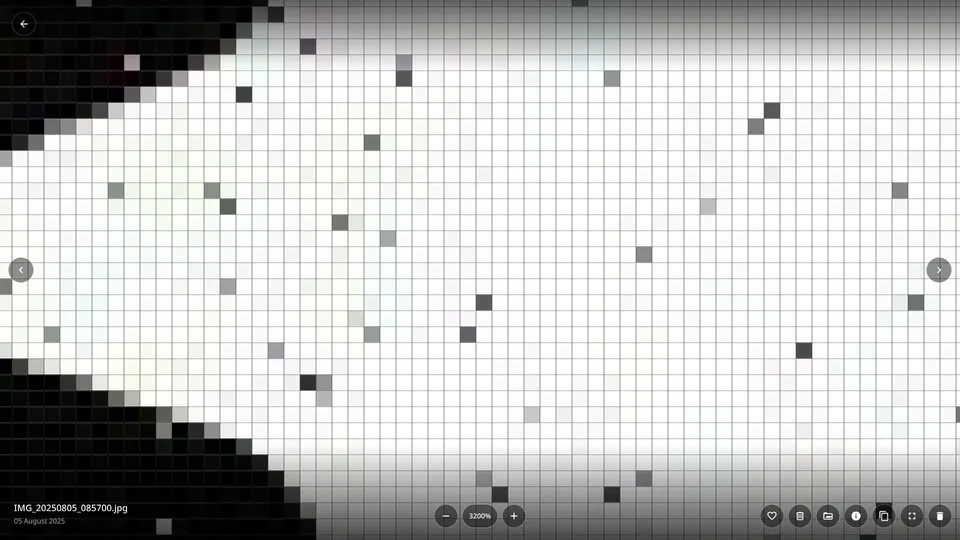 A photo zoomed to 3200 percent in Kader, with a grid outlining every pixel