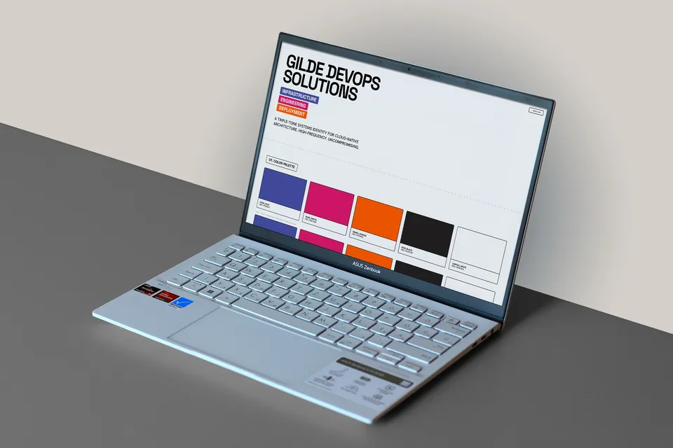Laptop on a grey desk showing the Gilde DevOps Solutions brand showcase page with the colour palette.