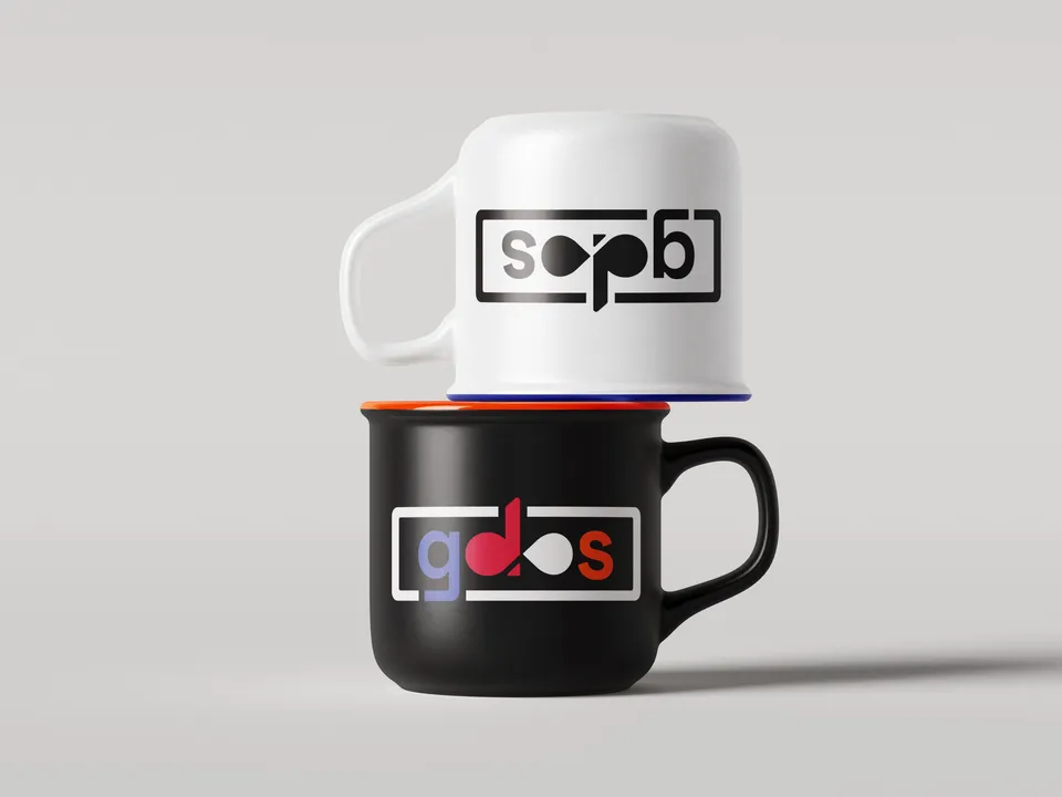 Two stacked enamel mugs with the gdos logo, a white one on top of a black one.