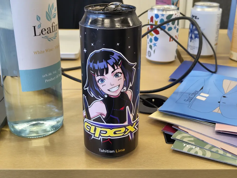 Printed Apex label wrapped around a drinks can on a work desk.